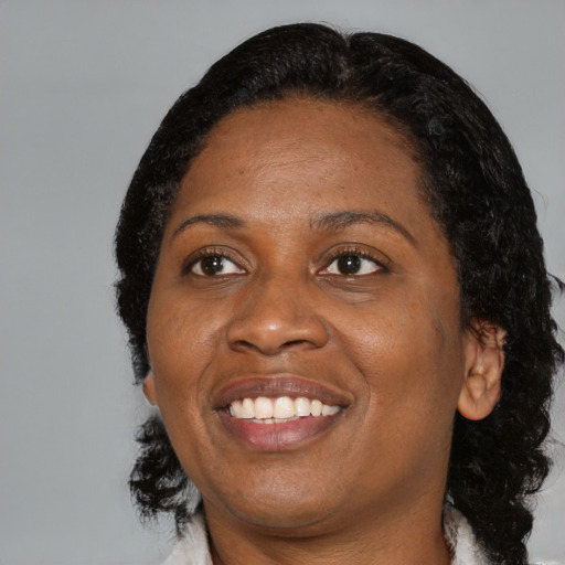 Joyful black adult female with medium  black hair and brown eyes