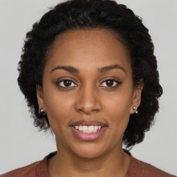 Joyful black young-adult female with short  brown hair and brown eyes