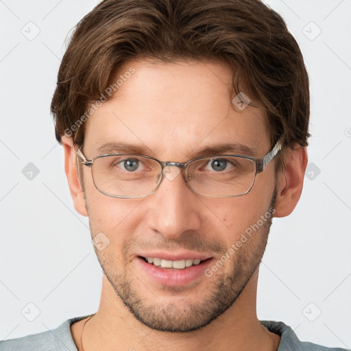 Joyful white young-adult male with short  brown hair and grey eyes