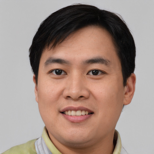 Joyful asian young-adult male with short  black hair and brown eyes