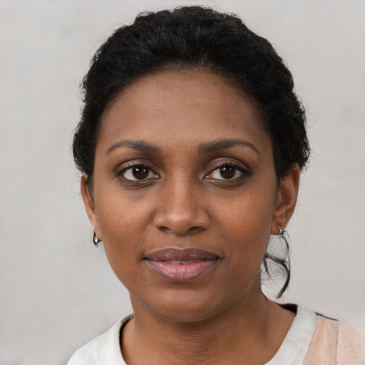 Joyful black young-adult female with short  brown hair and brown eyes