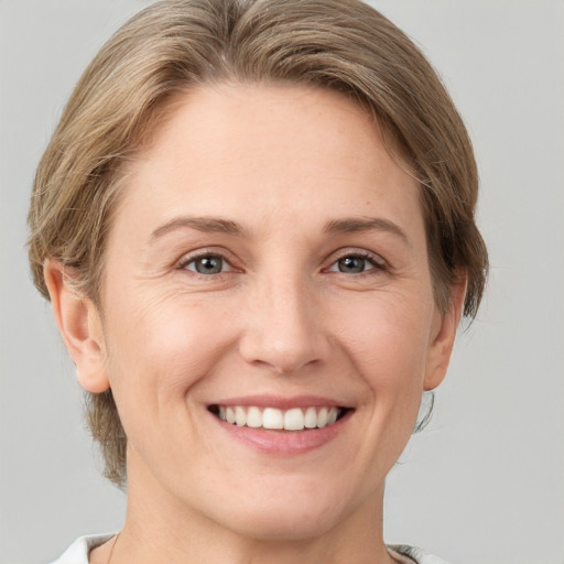 Joyful white young-adult female with short  brown hair and grey eyes