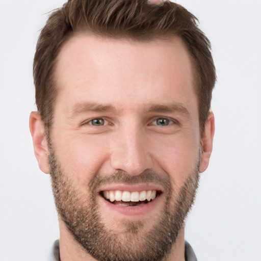 Joyful white young-adult male with short  brown hair and grey eyes