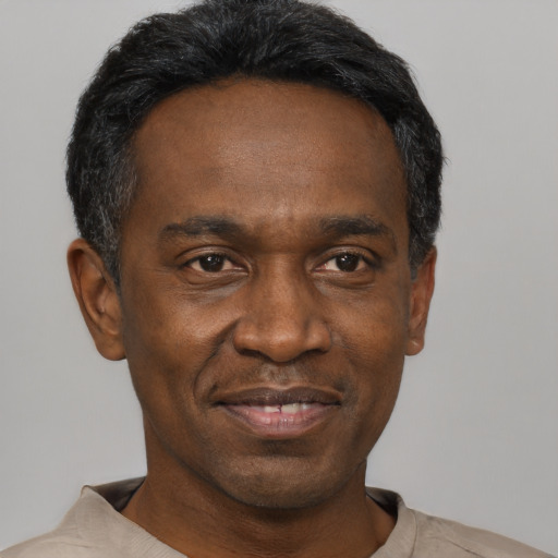 Joyful black adult male with short  black hair and brown eyes