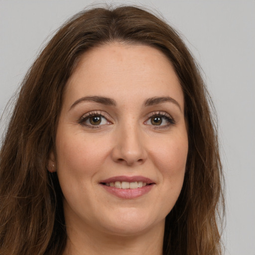 Joyful white young-adult female with long  brown hair and green eyes