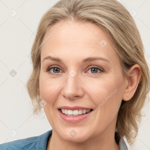 Joyful white adult female with medium  brown hair and blue eyes