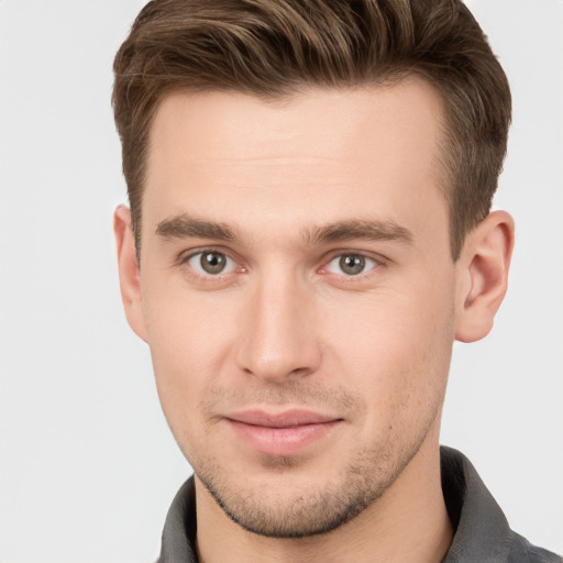 Joyful white young-adult male with short  brown hair and grey eyes