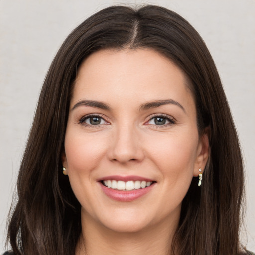 Joyful white young-adult female with long  brown hair and brown eyes