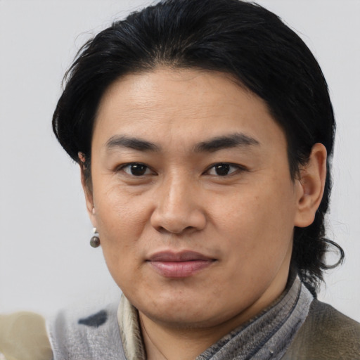 Joyful asian young-adult male with medium  brown hair and brown eyes