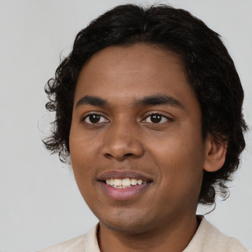 Joyful black young-adult male with medium  black hair and brown eyes