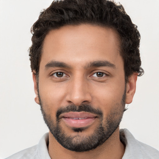 Joyful black young-adult male with short  brown hair and brown eyes