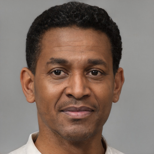 Joyful black adult male with short  black hair and brown eyes