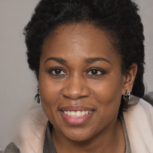 Joyful black young-adult female with short  brown hair and brown eyes