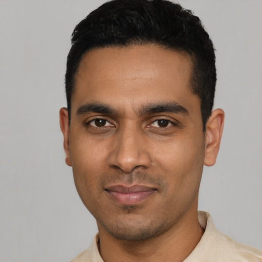 Joyful latino young-adult male with short  black hair and brown eyes