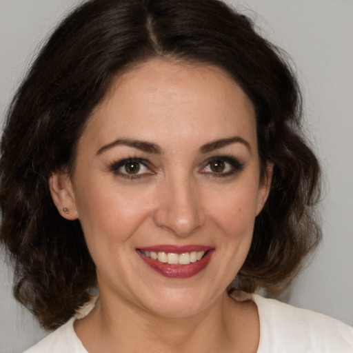 Joyful white adult female with medium  brown hair and brown eyes