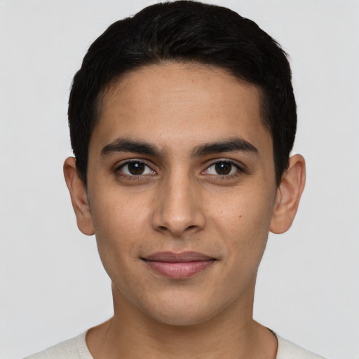 Joyful latino young-adult male with short  black hair and brown eyes