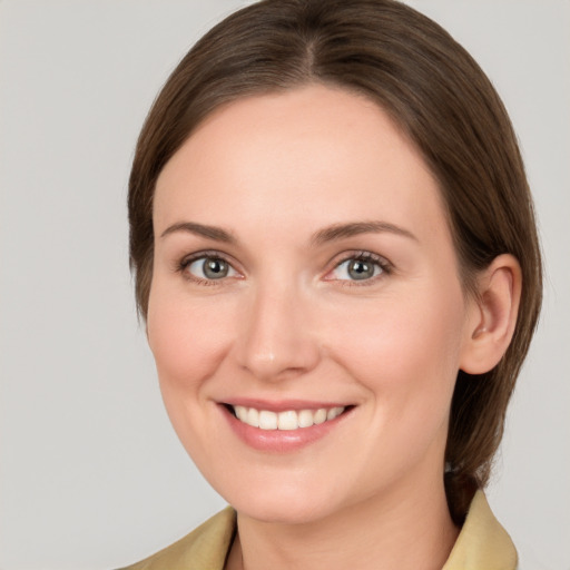 Joyful white young-adult female with medium  brown hair and grey eyes