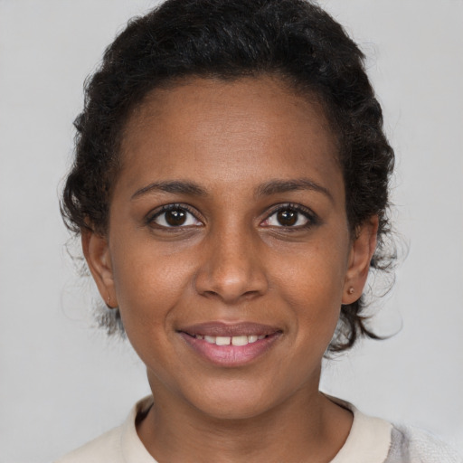 Joyful black young-adult female with short  brown hair and brown eyes