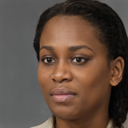 Joyful black young-adult female with long  black hair and brown eyes