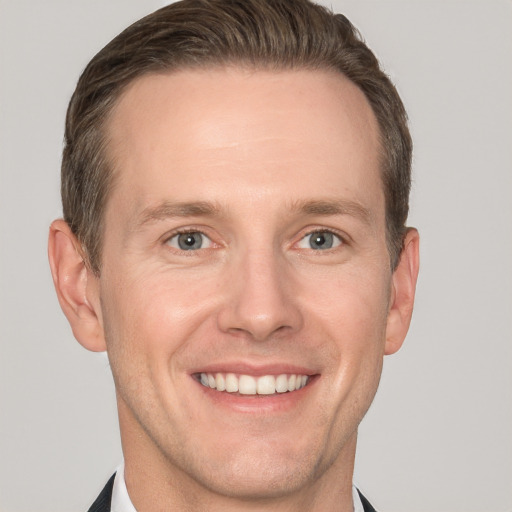 Joyful white adult male with short  brown hair and grey eyes