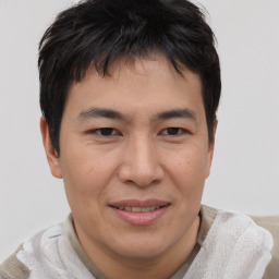 Joyful asian young-adult male with short  brown hair and brown eyes