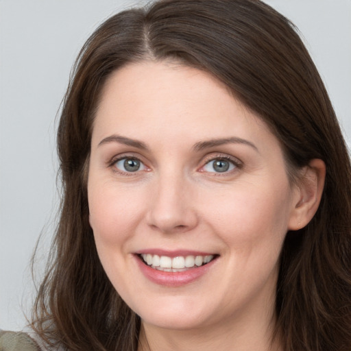 Joyful white young-adult female with long  brown hair and grey eyes