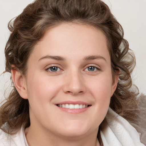 Joyful white young-adult female with medium  brown hair and blue eyes