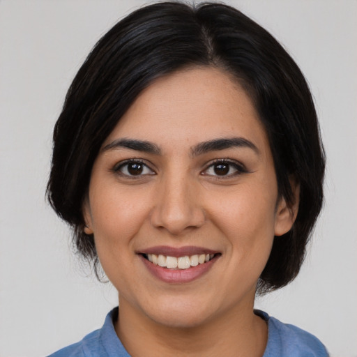 Joyful latino young-adult female with medium  brown hair and brown eyes