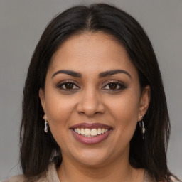 Joyful latino young-adult female with long  brown hair and brown eyes