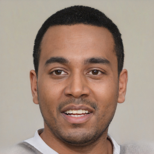Joyful black young-adult male with short  black hair and brown eyes