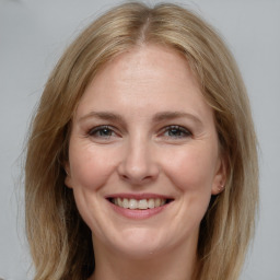 Joyful white adult female with medium  brown hair and grey eyes