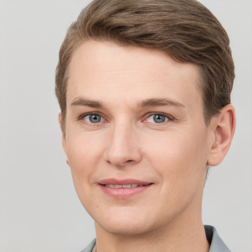 Joyful white young-adult male with short  brown hair and grey eyes