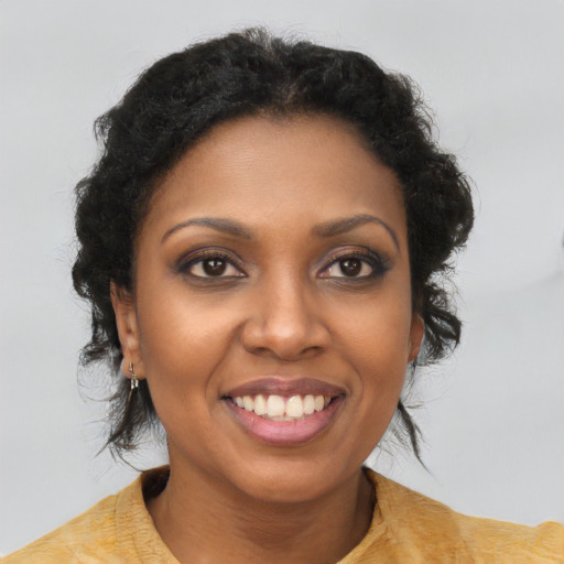 Joyful black young-adult female with long  brown hair and brown eyes