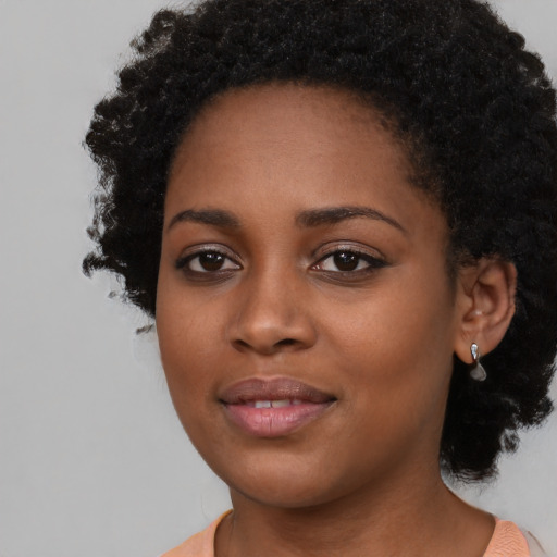 Joyful black young-adult female with medium  black hair and brown eyes