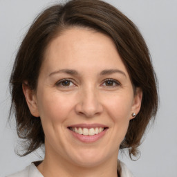 Joyful white adult female with medium  brown hair and brown eyes