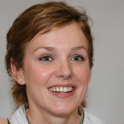 Joyful white young-adult female with medium  brown hair and blue eyes