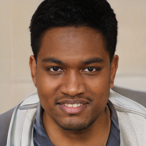 Joyful black young-adult male with short  brown hair and brown eyes