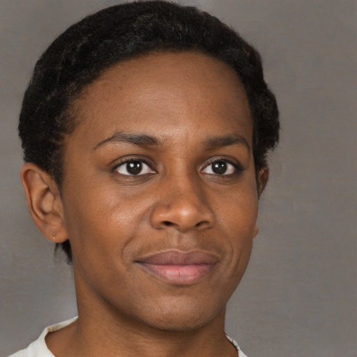 Joyful black young-adult female with short  brown hair and brown eyes
