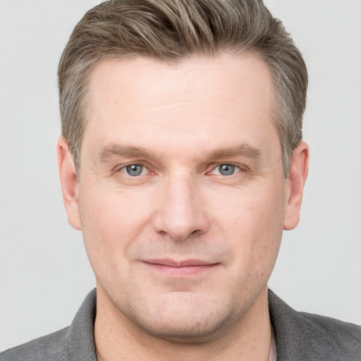 Joyful white adult male with short  brown hair and grey eyes