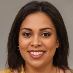 Joyful latino young-adult female with medium  brown hair and brown eyes