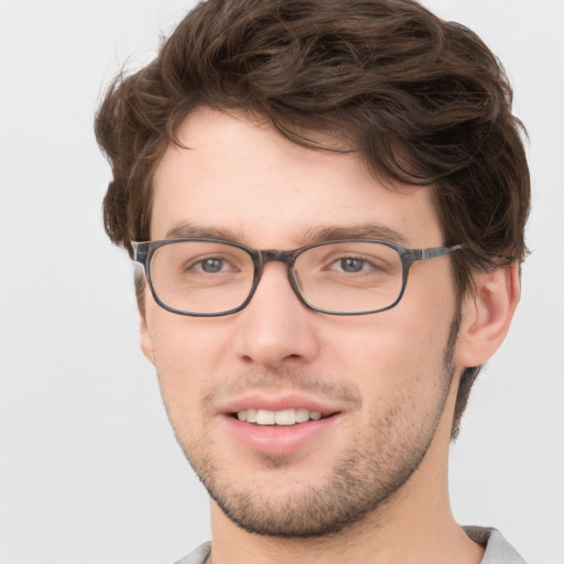 Joyful white young-adult male with short  brown hair and green eyes