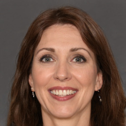 Joyful white adult female with long  brown hair and brown eyes