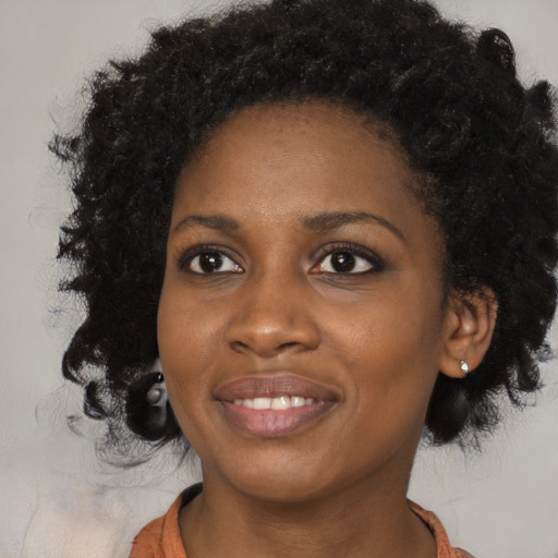 Joyful black young-adult female with medium  black hair and brown eyes