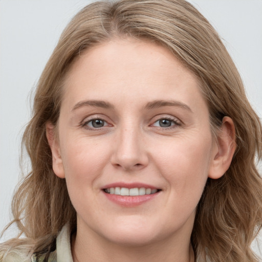 Joyful white young-adult female with long  brown hair and blue eyes