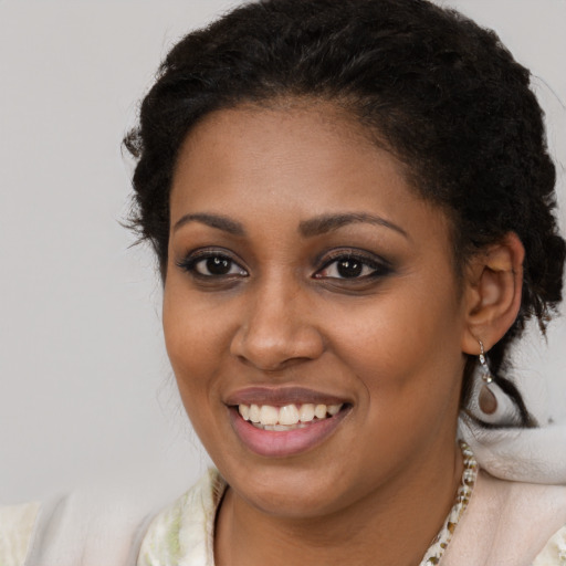 Joyful black young-adult female with long  brown hair and brown eyes