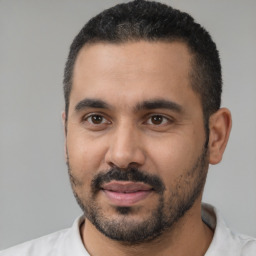 Joyful black young-adult male with short  black hair and brown eyes
