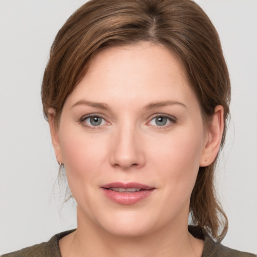 Joyful white young-adult female with medium  brown hair and grey eyes