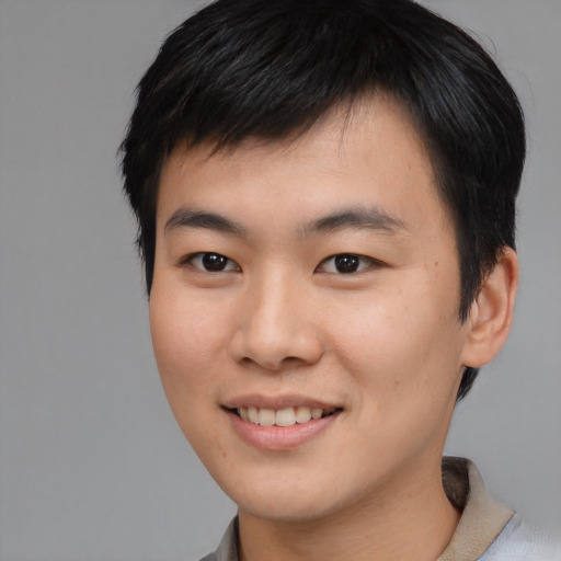 Joyful asian young-adult male with short  brown hair and brown eyes