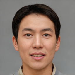 Joyful asian young-adult male with short  brown hair and brown eyes