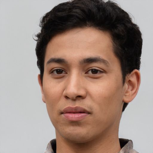 Joyful latino young-adult male with short  brown hair and brown eyes
